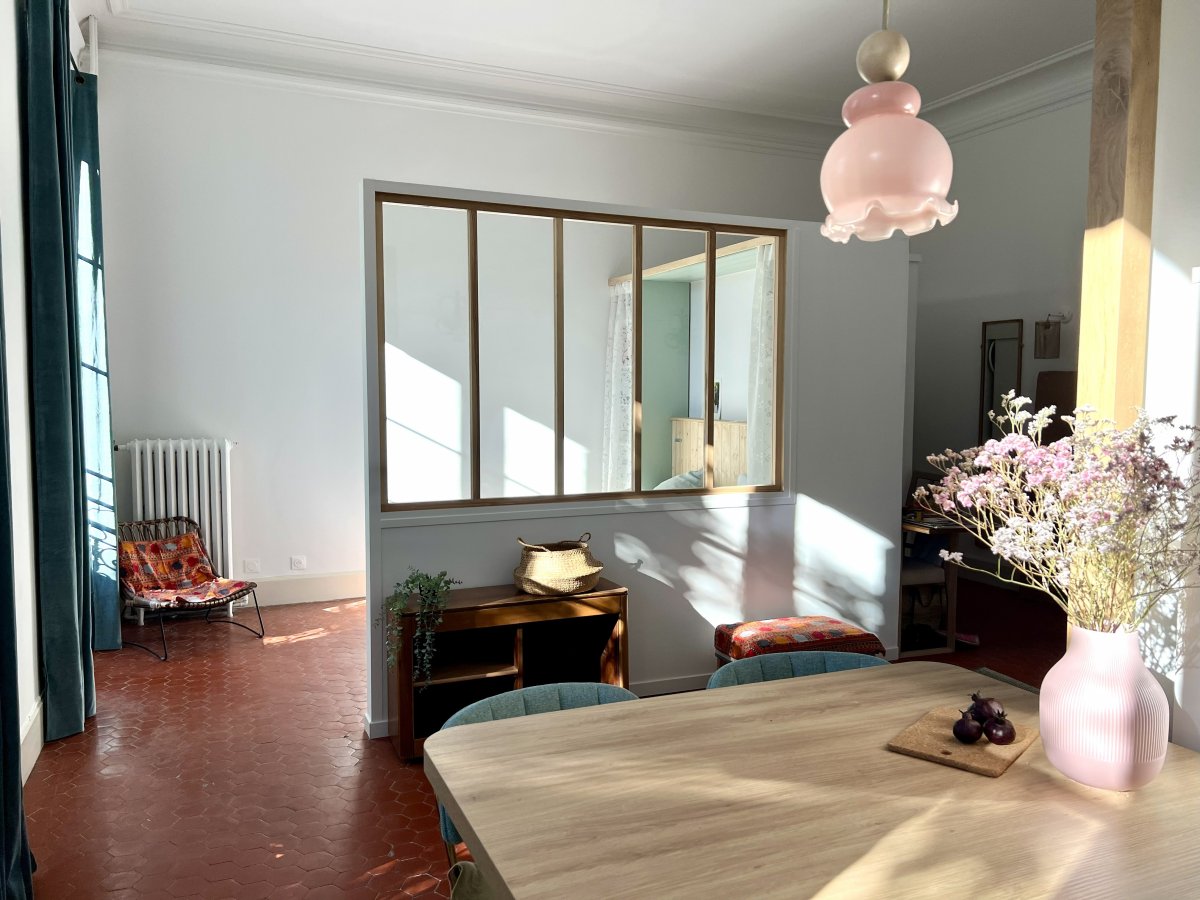 Avant-Après, vue Après du séjour et coin nuit pris depuis la cuisine dans le studio rénové à Avignon. Avant-Après, Projet du studio d'Avignon, vue Après du séjour et coin nuit pris depuis la cuisine. Sol tomettes et luminaire fabriqué à partir de verrerie chinée